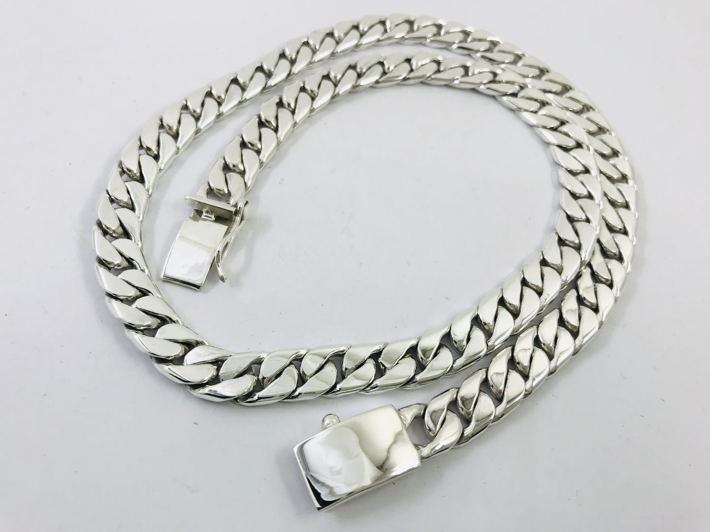 Silver chain belt with clasp on a light gray background